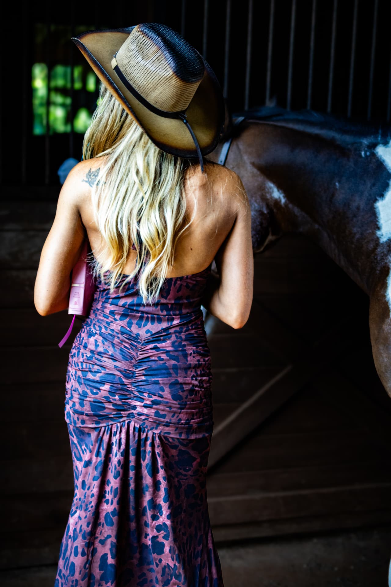 Aubree photographed from behind in a straw cowboy hat, long dimensional blonde hair falling down her back